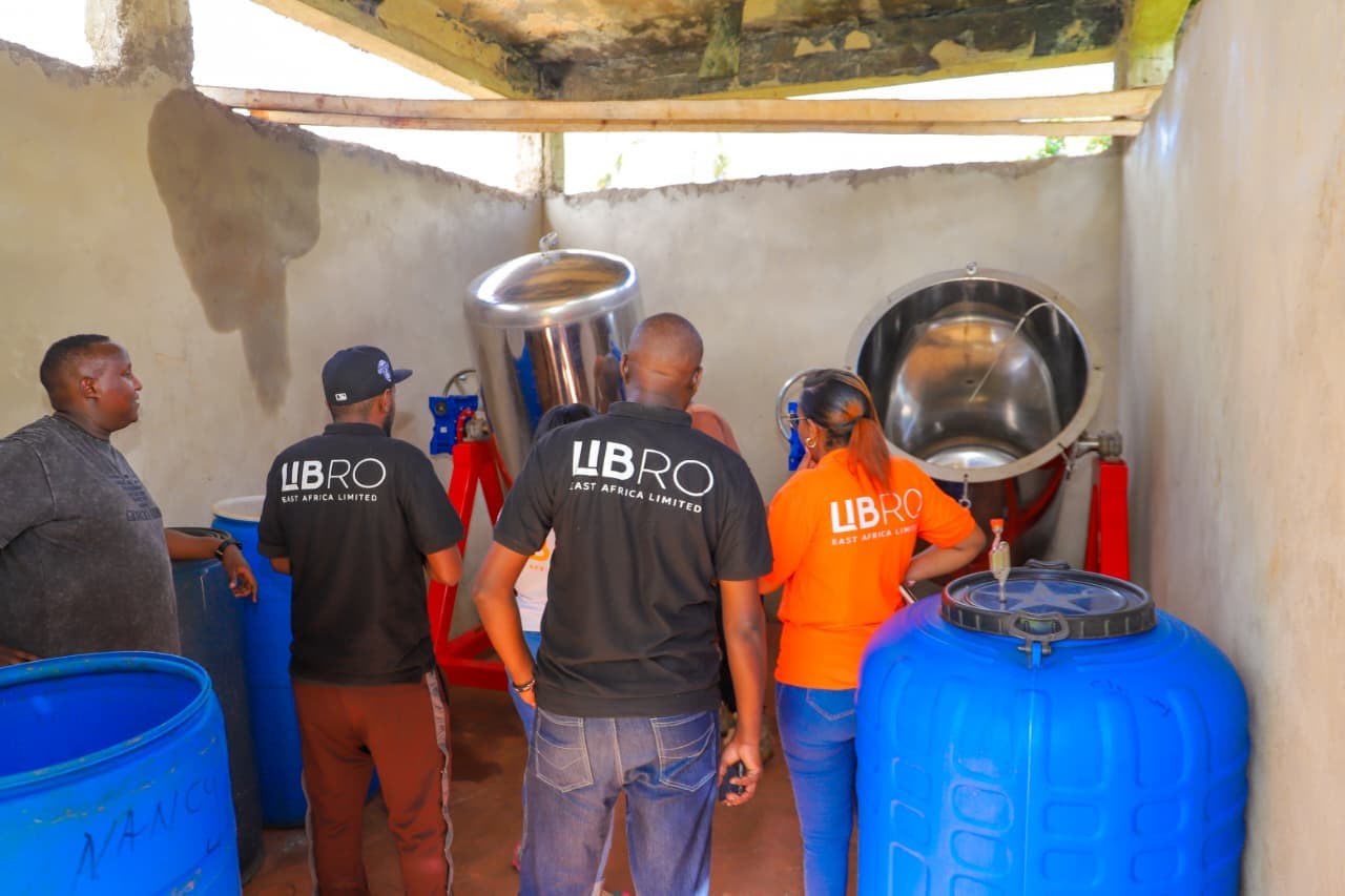 Kenyan coffee washing station with stainless steel processing vessels and team in Libro branded uniforms