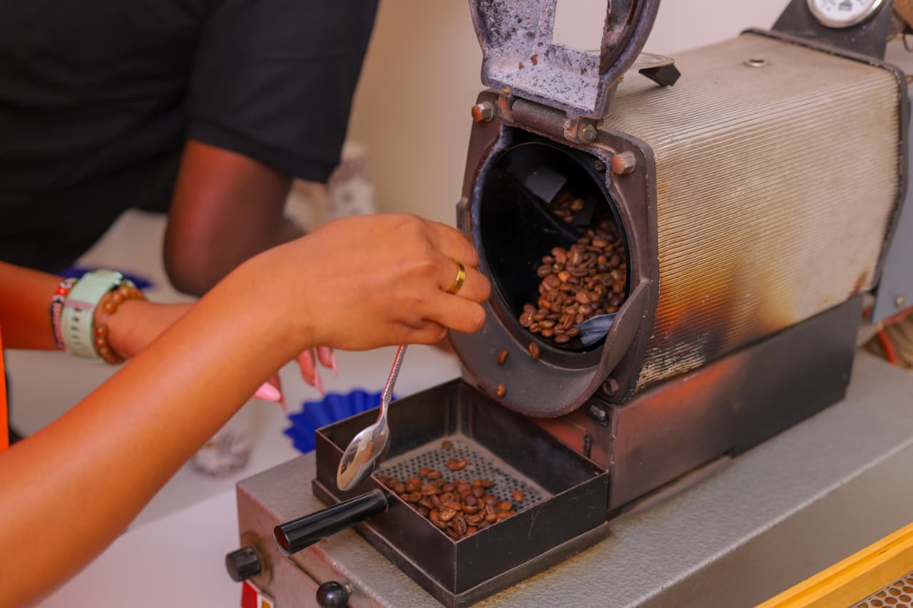 Team member operating a sample lab coffee roaster at Libro East Africa quality control facility